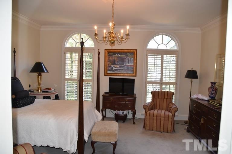 809 Lassiter Place Raleigh, NC 27609 - Photo 14 of 25 a bedroom with furniture a fireplace and a chandelier