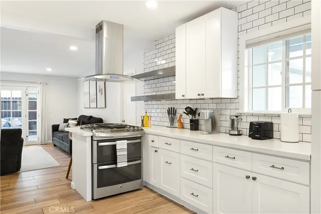 a kitchen with stainless steel appliances granite countertop a stove a sink and white cabinets