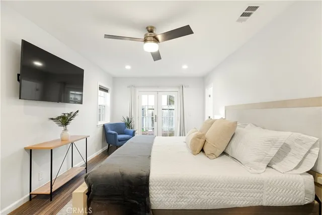 a bedroom with a large bed and a flat screen tv