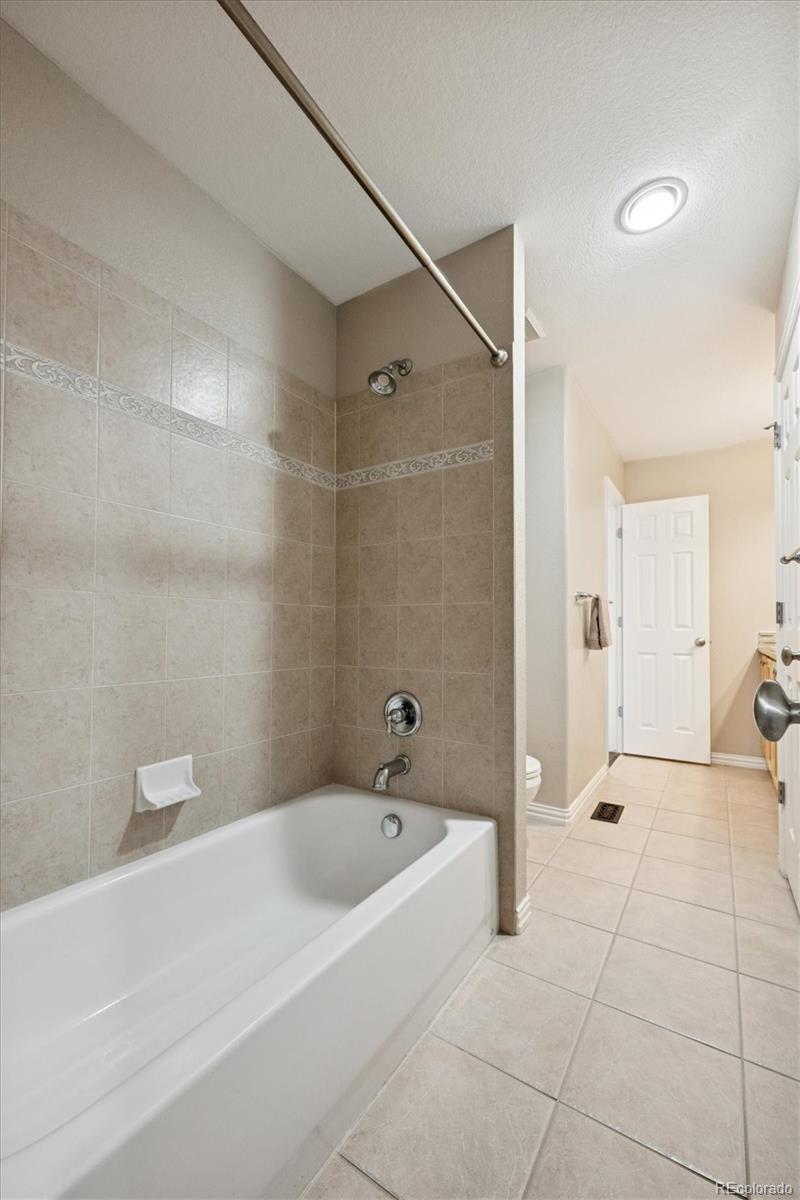 3431 Grove Street Brighton, CO 80601 - Photo 25 of 34 a bathroom with a bathtub and a shower