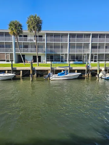 a view of pool with a small yard and large trees