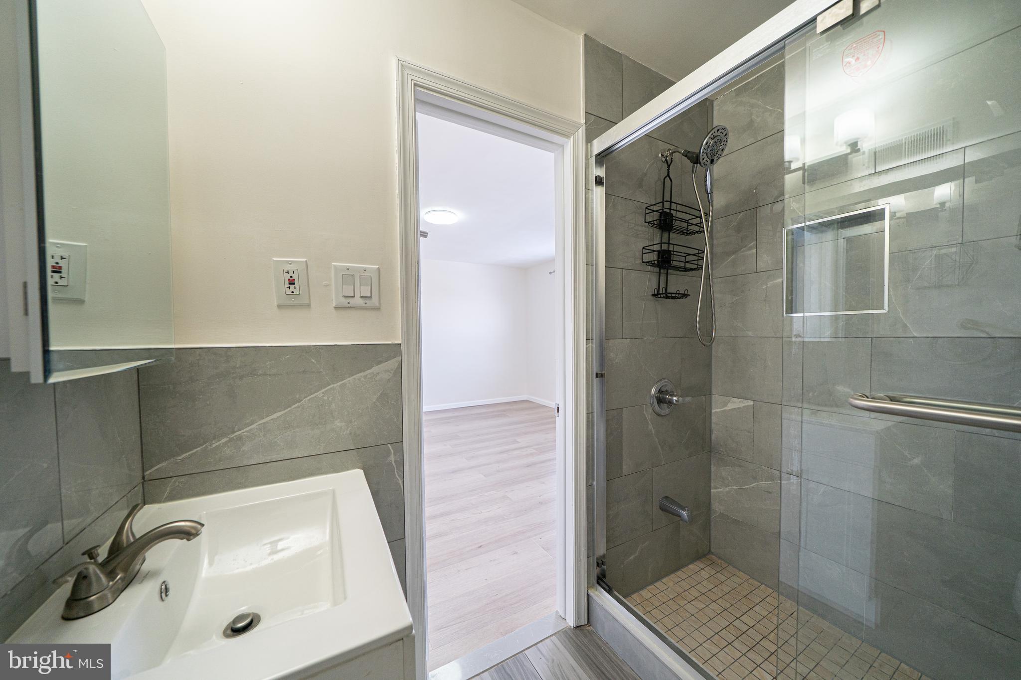 3674 Salina Road Philadelphia, PA 19154 - Photo 11 of 22 a bathroom with a sink a glass door shower and a mirror