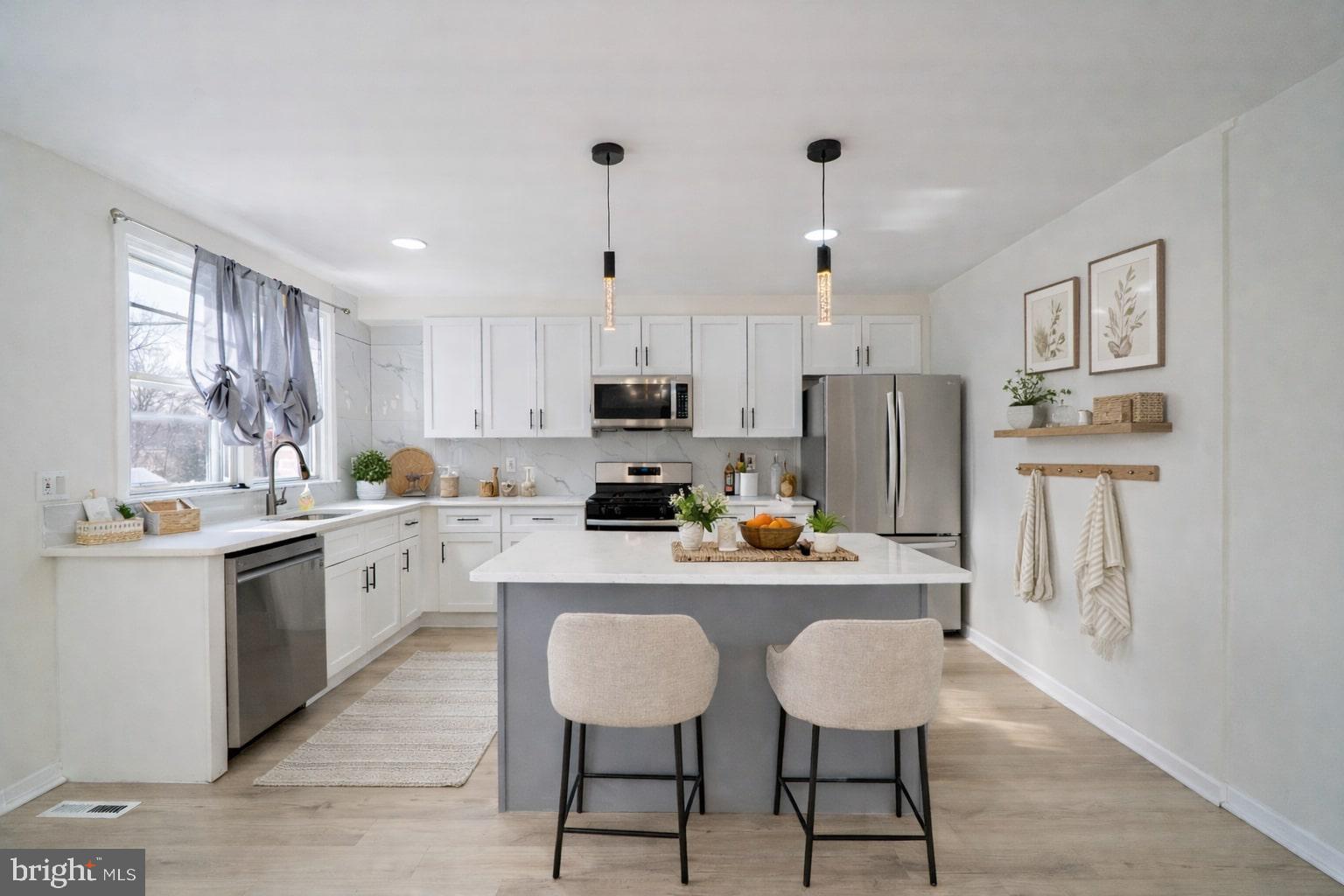 3674 Salina Road Philadelphia, PA 19154 - Photo 6 of 22 a kitchen with stainless steel appliances granite countertop a stove top oven a refrigerator a sink and white cabinets with wooden floor