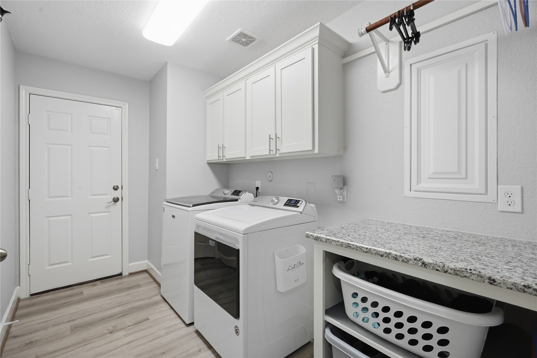 615 Lilley Road Alvin, TX 77511 - Photo 23 of 42 Utility room located inside the home with convenient granite counter and built-in clothes basket storage.