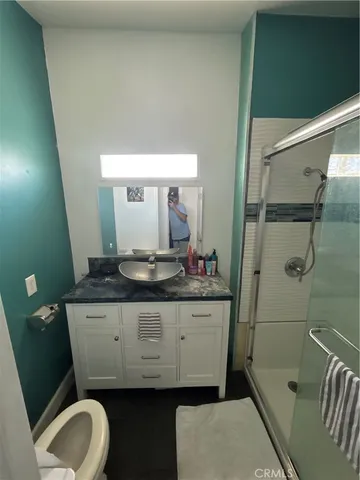 a bathroom with a granite countertop sink a mirror and toilet