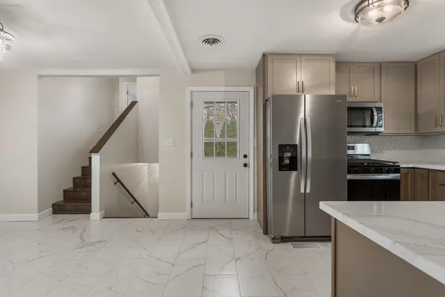 a kitchen with stainless steel appliances a refrigerator and a stove top oven
