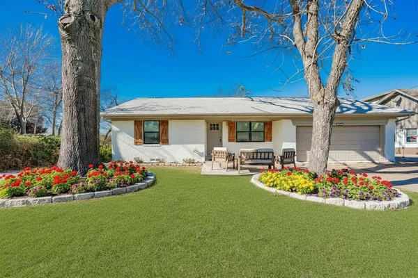 a front view of a house with a garden and patio