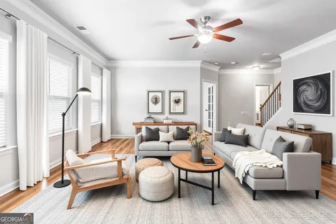 a living room with furniture a ceiling fan and a rug