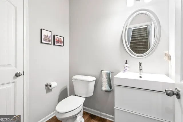 a bathroom with a toilet a sink and mirror