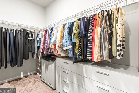 a view of walk in closet with clothes