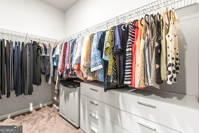 a view of walk in closet with clothes
