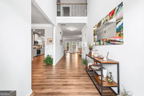 a view of a hallway with wooden floor and furniture