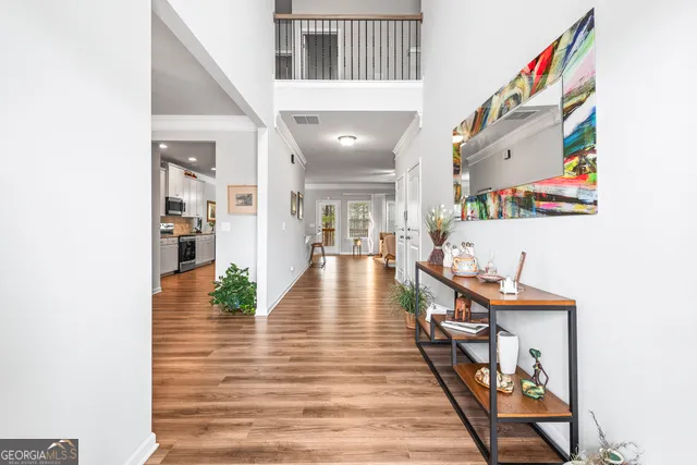 a view of a hallway with wooden floor and furniture
