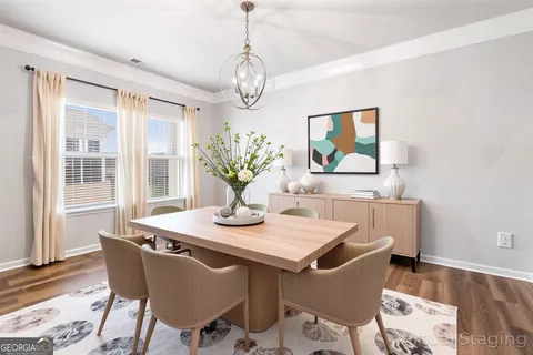 a dining room with wooden floor a chandelier a wooden table and chairs