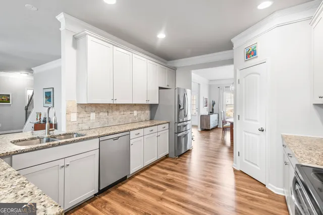 a kitchen with a sink cabinets and wooden floor