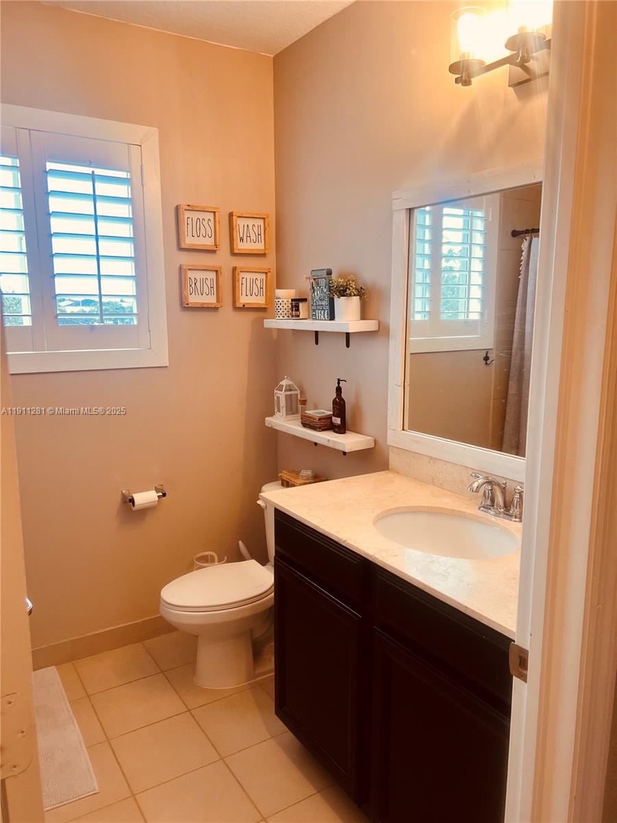 12780 Southwest 224th Street Miami, FL 33170 - Photo 17 of 29 a bathroom with a granite countertop sink toilet and mirror