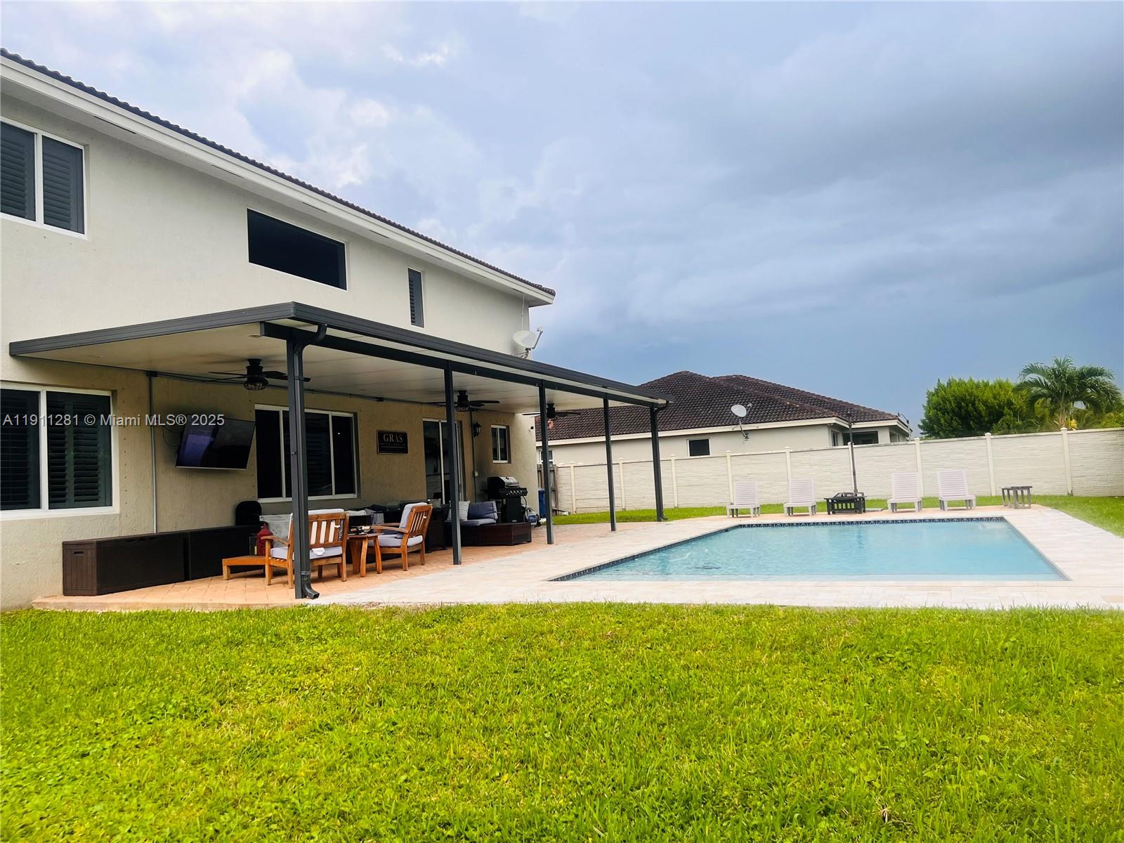 12780 Southwest 224th Street Miami, FL 33170 - Photo 27 of 29 a view of a patio with table and chairs under an umbrella