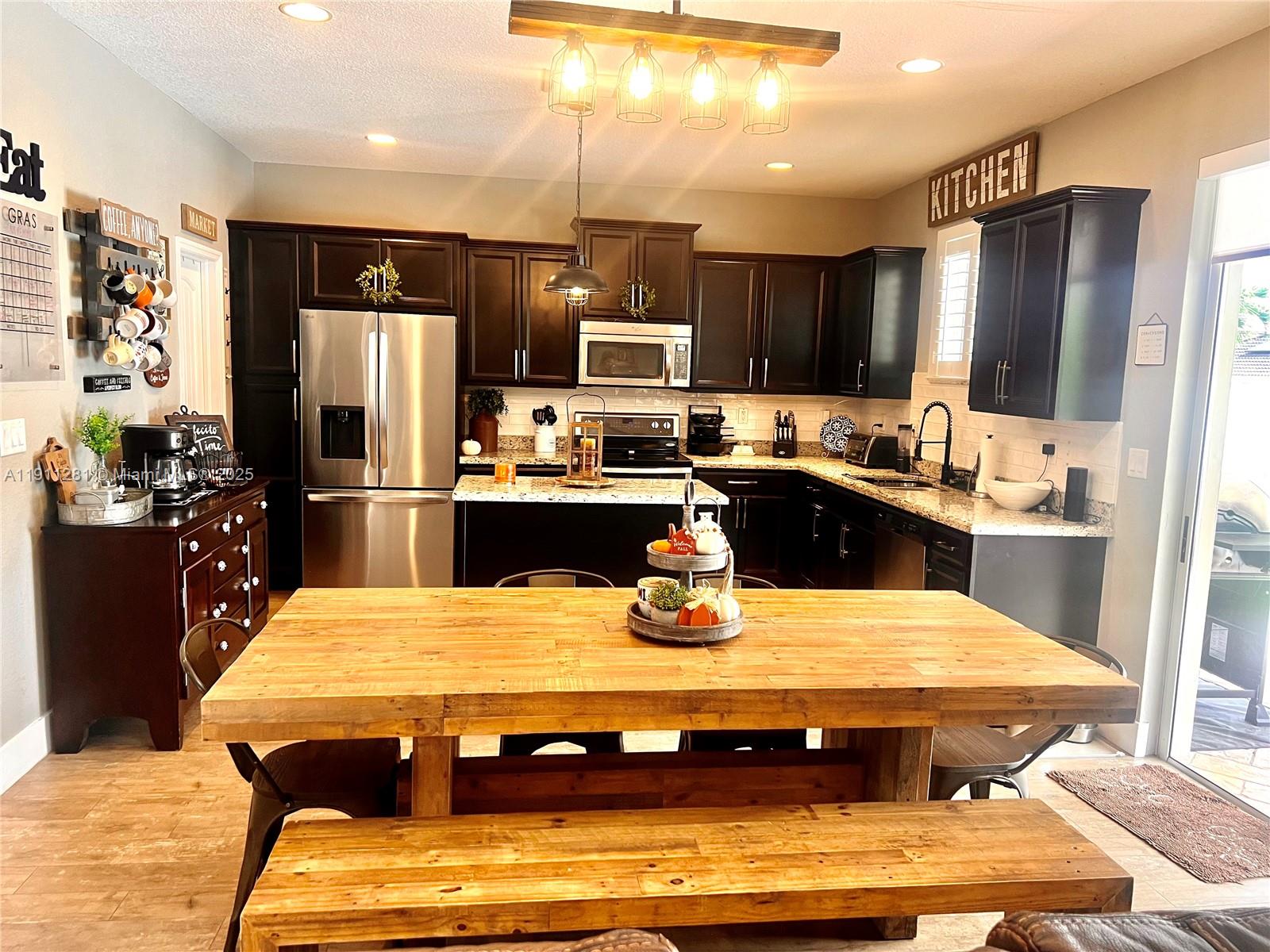 12780 Southwest 224th Street Miami, FL 33170 - Photo 6 of 29 a kitchen with stainless steel appliances granite countertop a sink refrigerator and cabinets