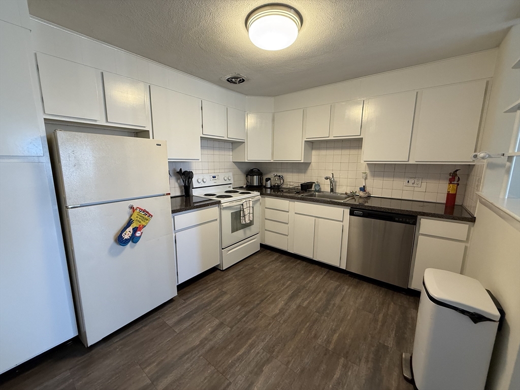 a kitchen with stainless steel appliances a refrigerator sink and wooden floor
