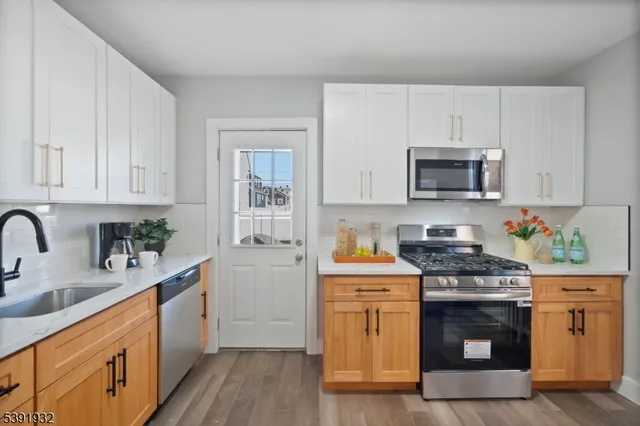 a kitchen with stainless steel appliances a stove a sink a stove and cabinets