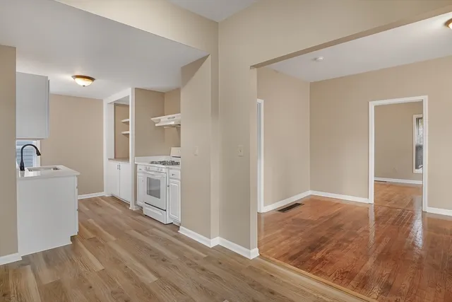 a view of a kitchen with wooden floor and a sink