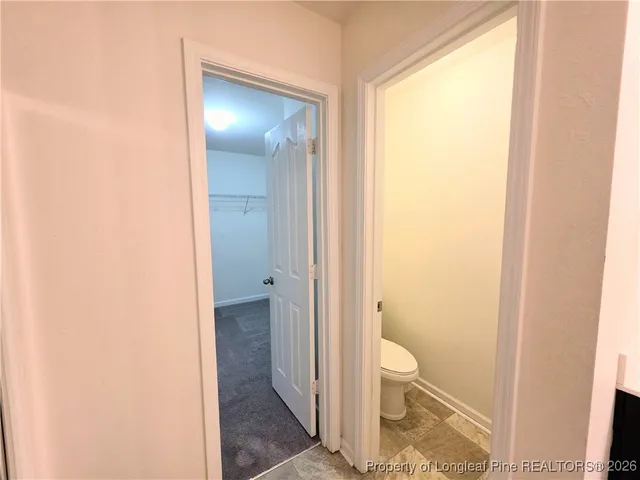 a bathroom with a granite countertop sink and a toilet