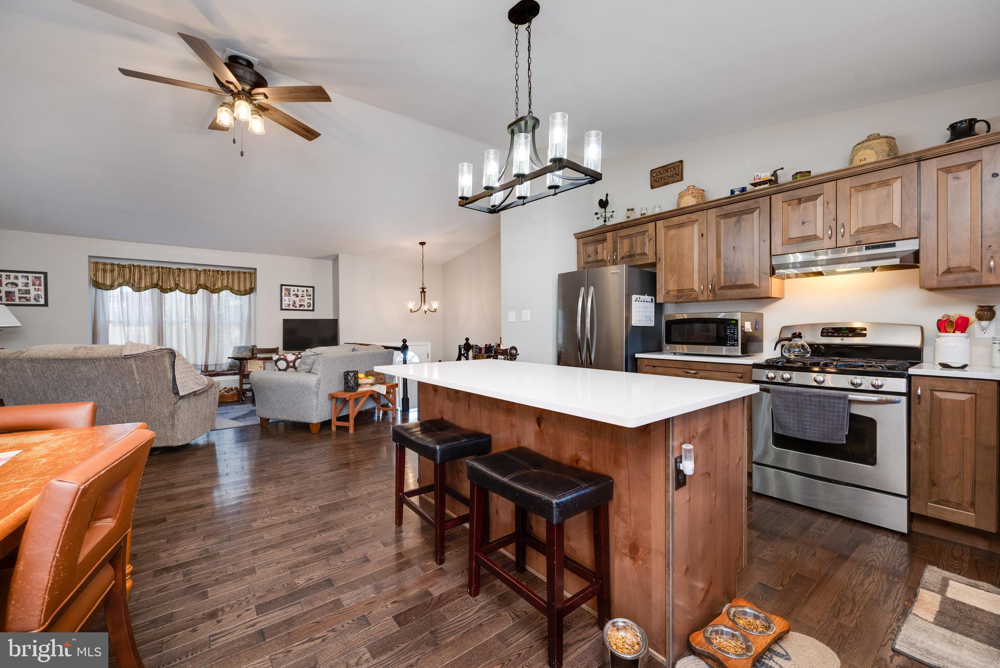 1133 Ashbourne Drive Reading, PA 19605 - Photo 18 of 64 a kitchen with stainless steel appliances a stove a sink a dining table and chairs with wooden floor