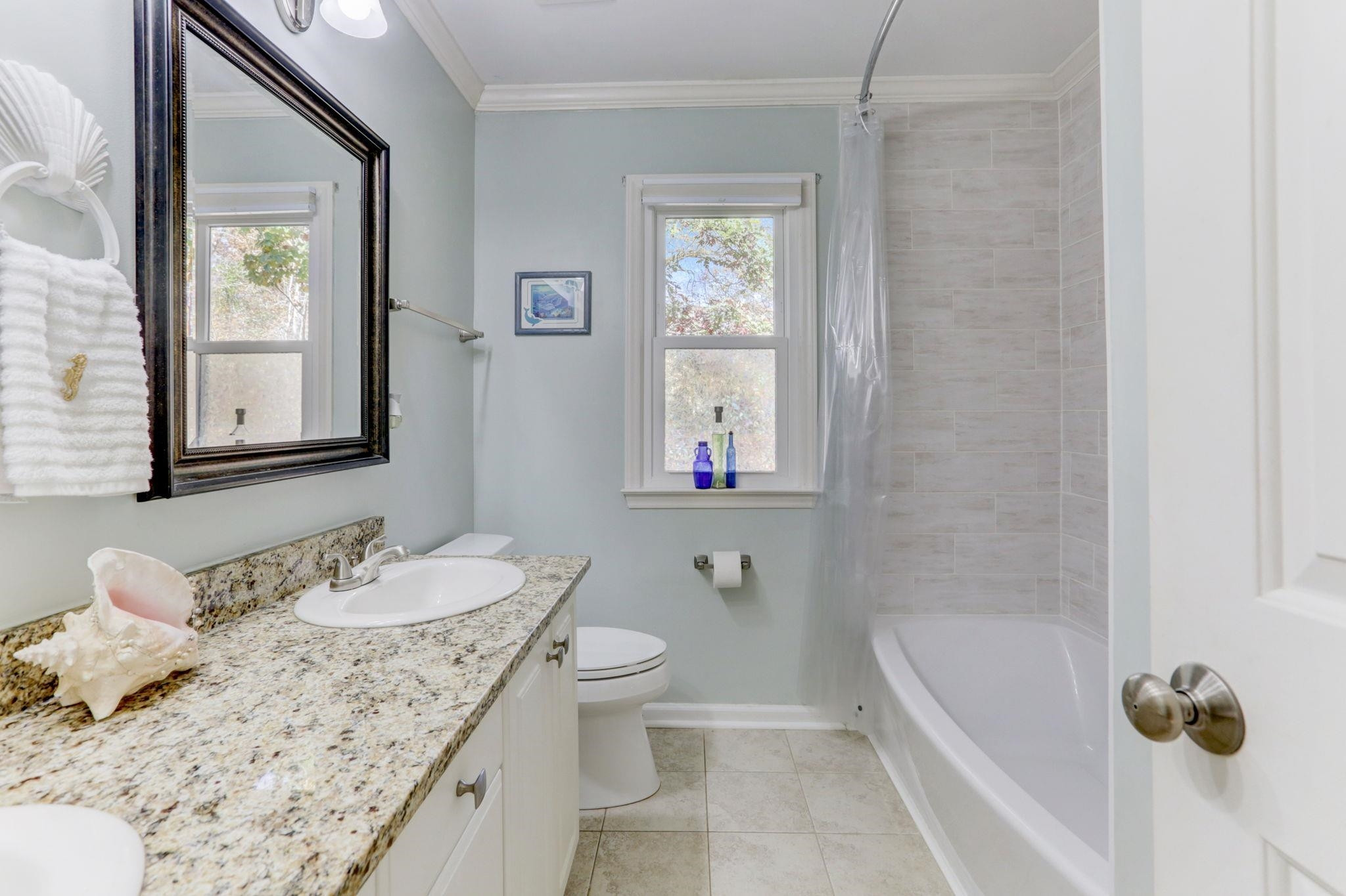 3 Danforth Place Durham, NC 27712 - Photo 22 of 38 a bathroom with a granite countertop sink and a mirror