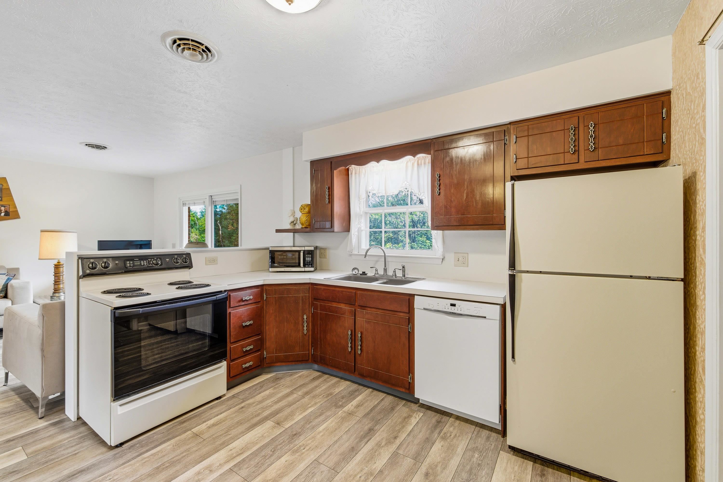 44 Emery Street Harrisonburg, VA 22801 - Photo 4 of 75 The kitchen in the home features laminant flooring throughout, wooden cabinetry, recessed lighting, double-bowl sink, and an open-concept easily flowing into the dining area and living room of the home.