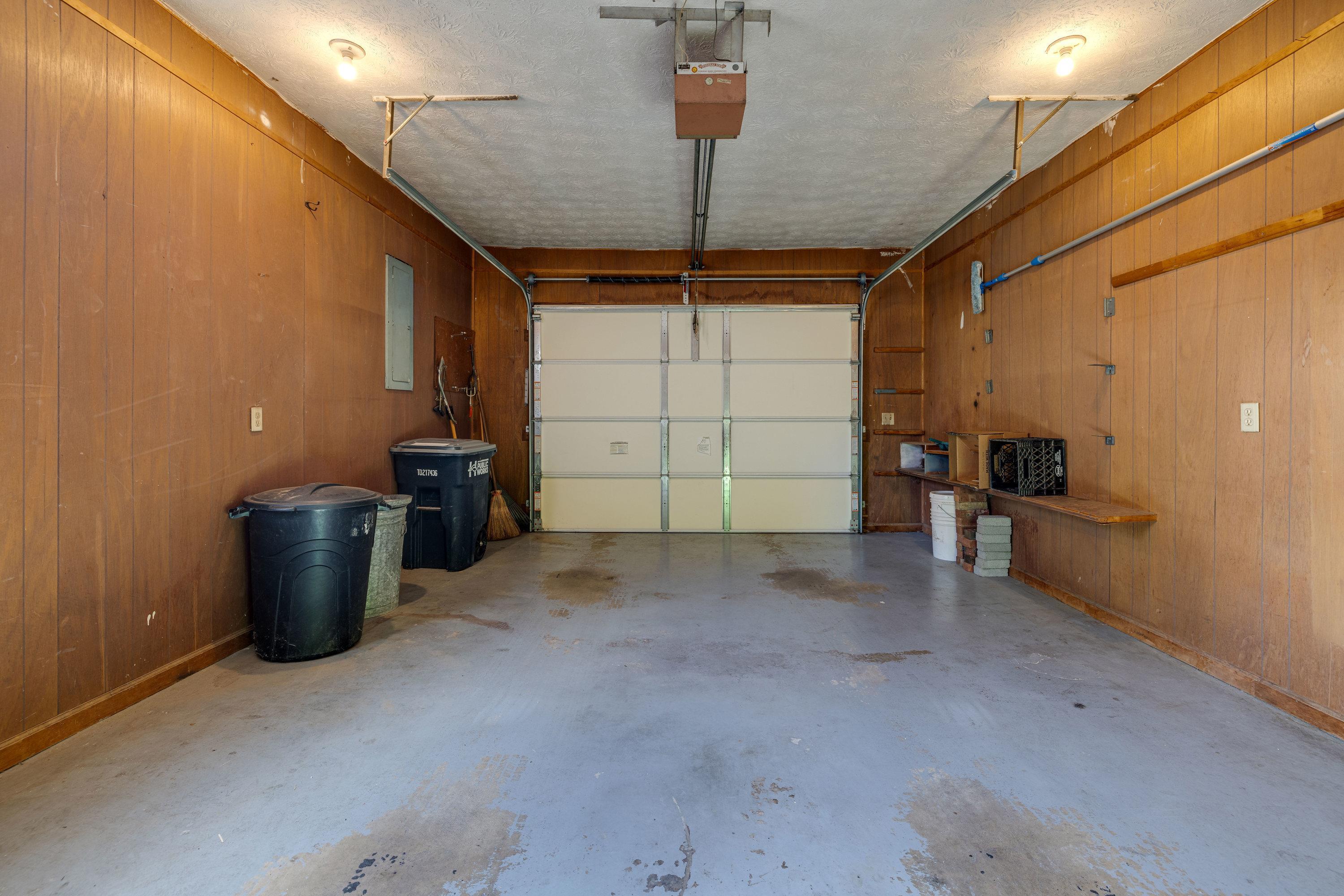 44 Emery Street Harrisonburg, VA 22801 - Photo 45 of 75 A single car garage contains shelving for storage and an automatic door.
