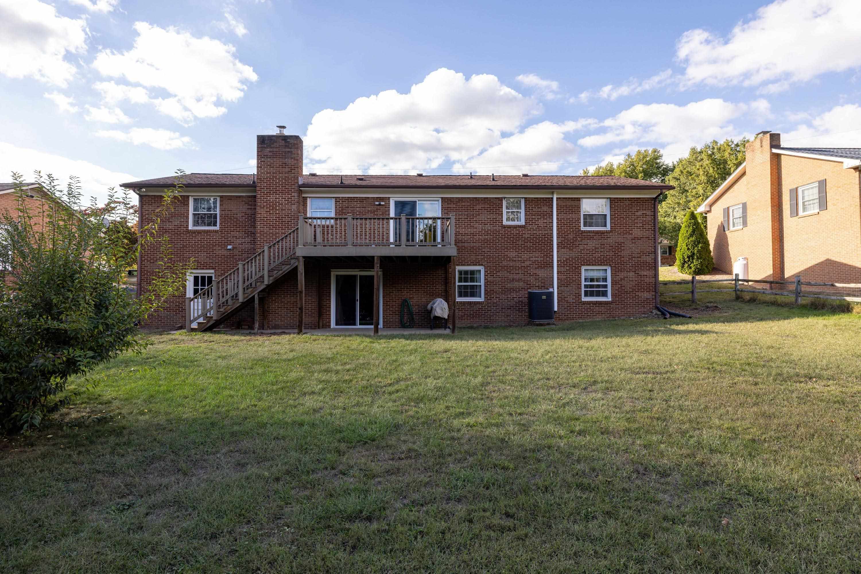 44 Emery Street Harrisonburg, VA 22801 - Photo 61 of 75 The rear view of the home highlights the large deck off the rear of the home, covered patio area, and spacious back yard that is fully fenced.