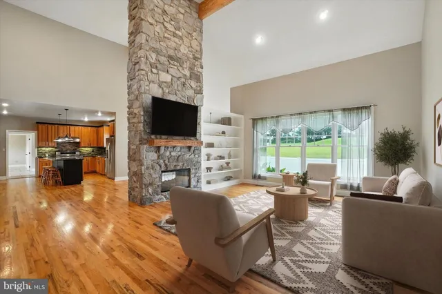 a kitchen with stainless steel appliances granite countertop a stove a sink dishwasher and a refrigerator with wooden floor