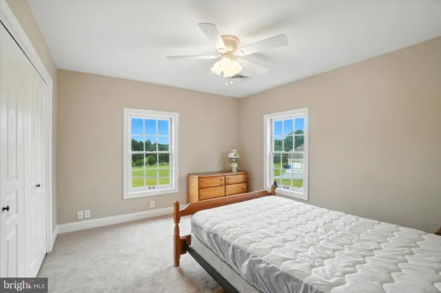 a view of a big room with windows and chandelier fan