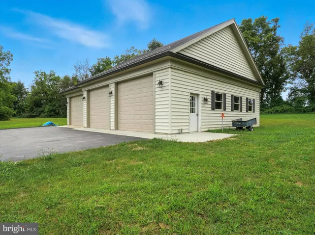 a view of a street with a big yard and a large tree