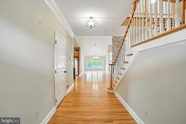 a view of a hallway with wooden floor and staircase