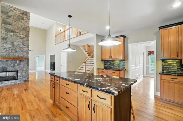 a kitchen with stainless steel appliances granite countertop a stove and a wooden floor