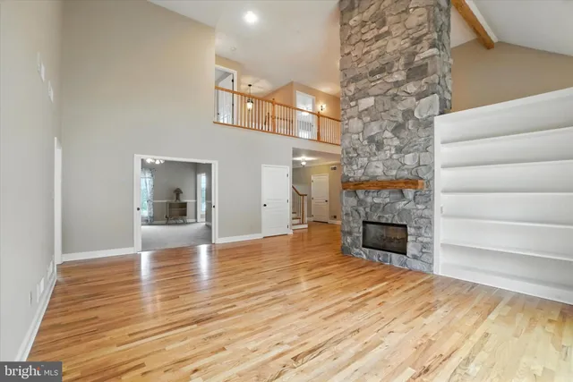 a view of empty room with fireplace and wooden floor