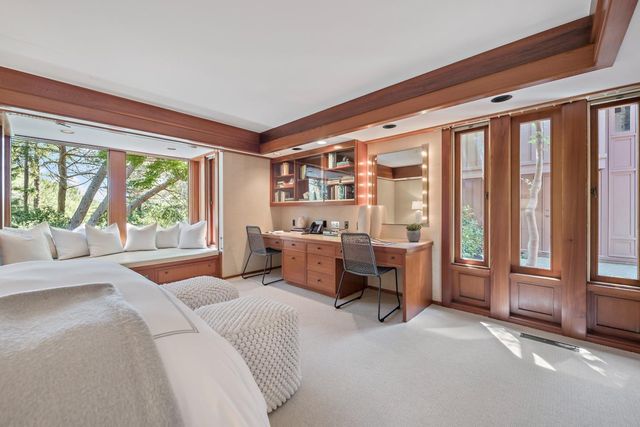 a bedroom with furniture and large windows