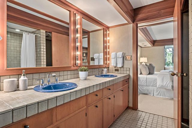 a en suite bathroom with a granite countertop sink and a mirror