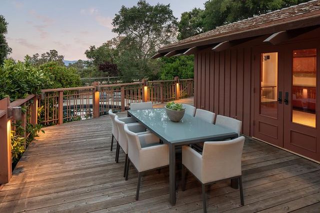a balcony with wooden floor table and chairs