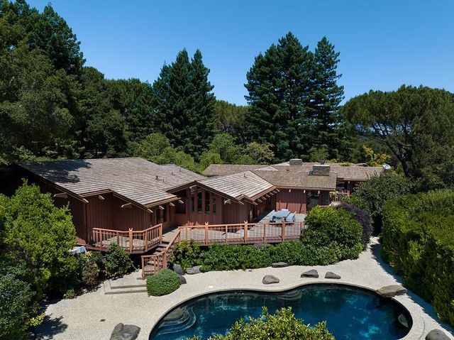 an aerial view of a house with swimming pool and garden view