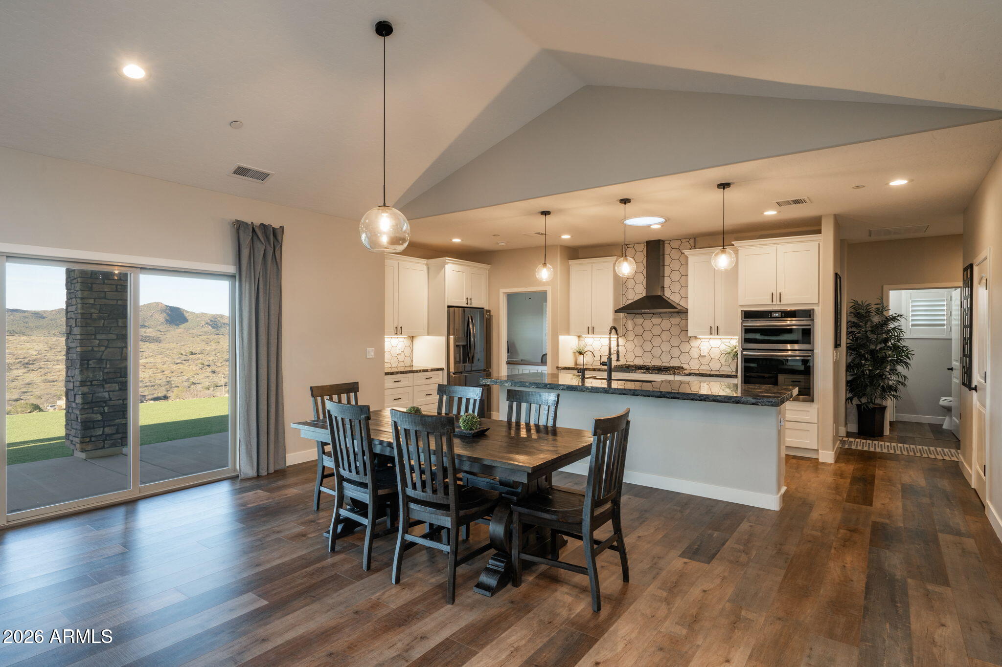15140 East Countryside Road Mayer, AZ 86333 - Photo 13 of 67 a view of a dining room and livingroom with furniture wooden floor a chandelier