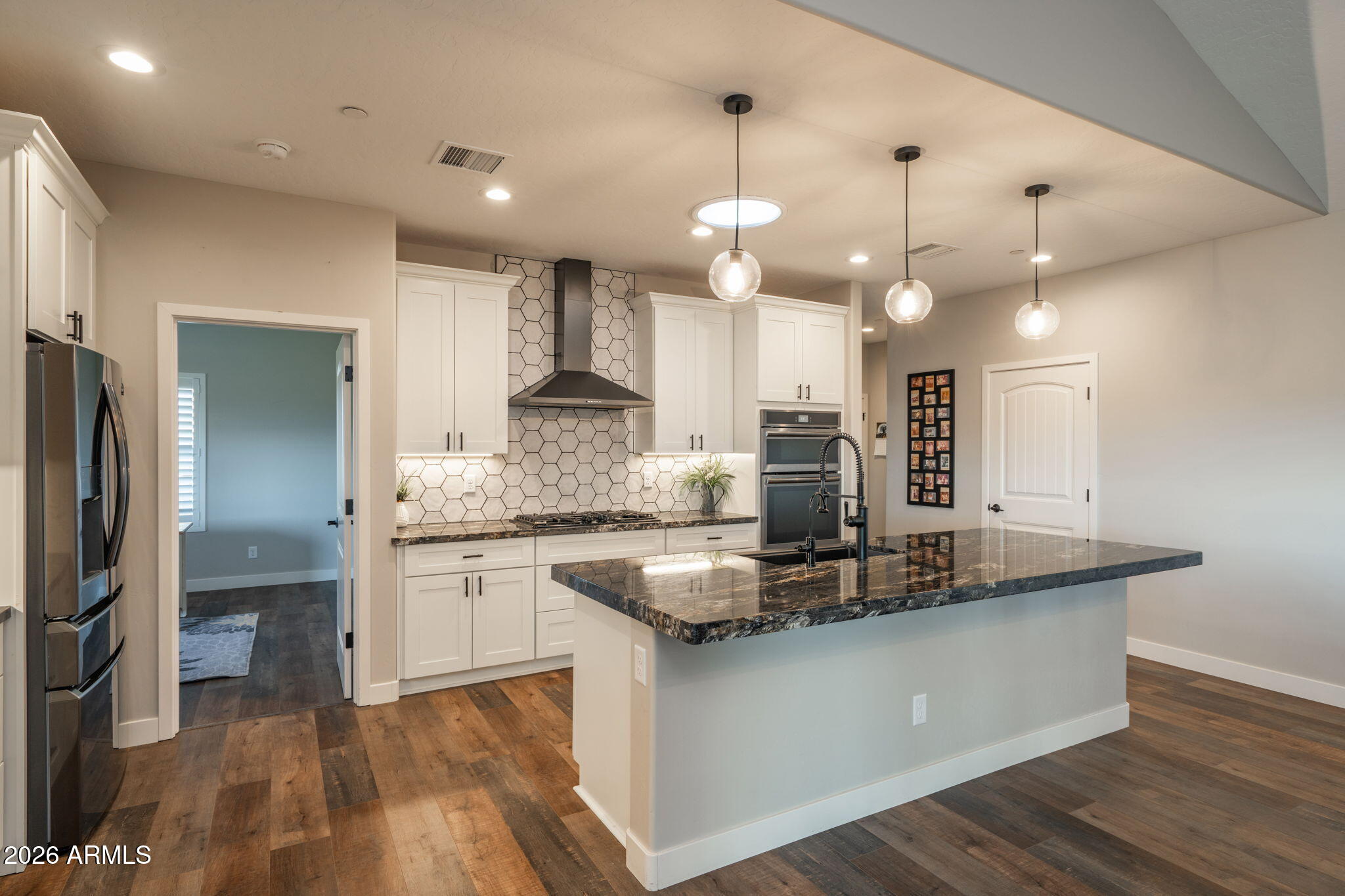 15140 East Countryside Road Mayer, AZ 86333 - Photo 15 of 67 a kitchen with kitchen island granite countertop a sink a counter and stainless steel appliances