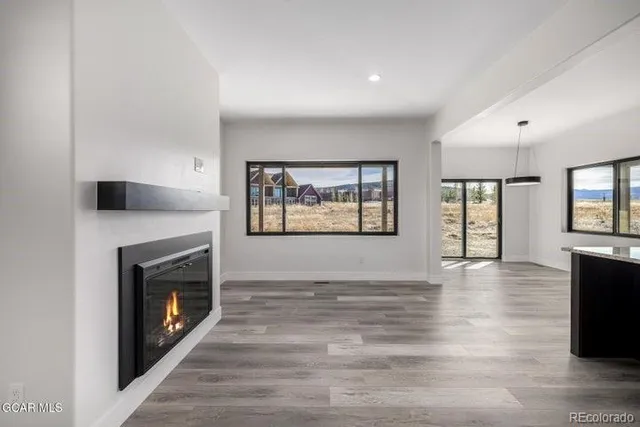 a view of an empty room with a window and a fireplace