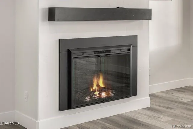 a view of an empty room with window and hardwood floor