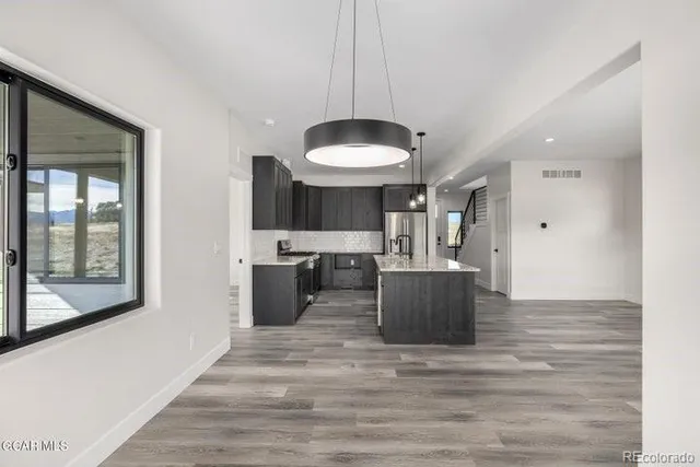 a kitchen with kitchen island granite countertop a sink stove and refrigerator