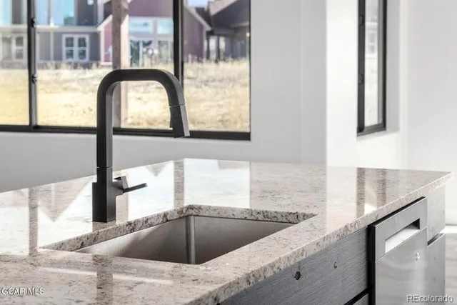 a kitchen with stainless steel appliances granite countertop a sink a refrigerator a counter and a refrigerator