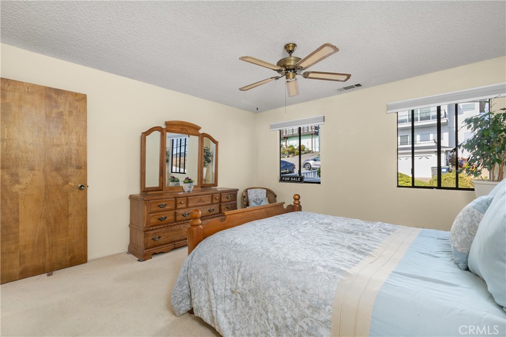 2631 Nutmeg Avenue Morro Bay, CA 93442 - Photo 15 of 39 a bedroom with a large bed and a chandelier