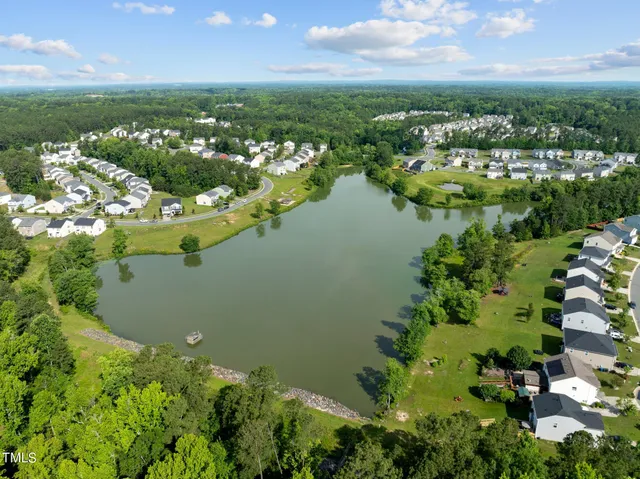 an aerial view of residential houses with outdoor space and lake view