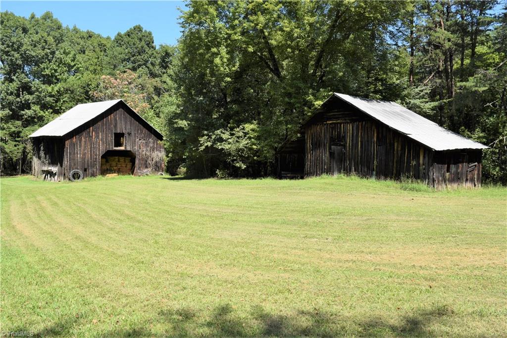1030 Ellisboro Road Madison, NC 27025 - Photo 13 of 30 So Much History! 2 amazing structures that are still in pretty good shape. Animal barn currently being used to store hay. Multiple stalls, open on both ends, hay loft on 2nd level. The other structure is a old tobacco barn with lien to on both sides. Still has a few pieces of tobacco still hanging in the rafters.